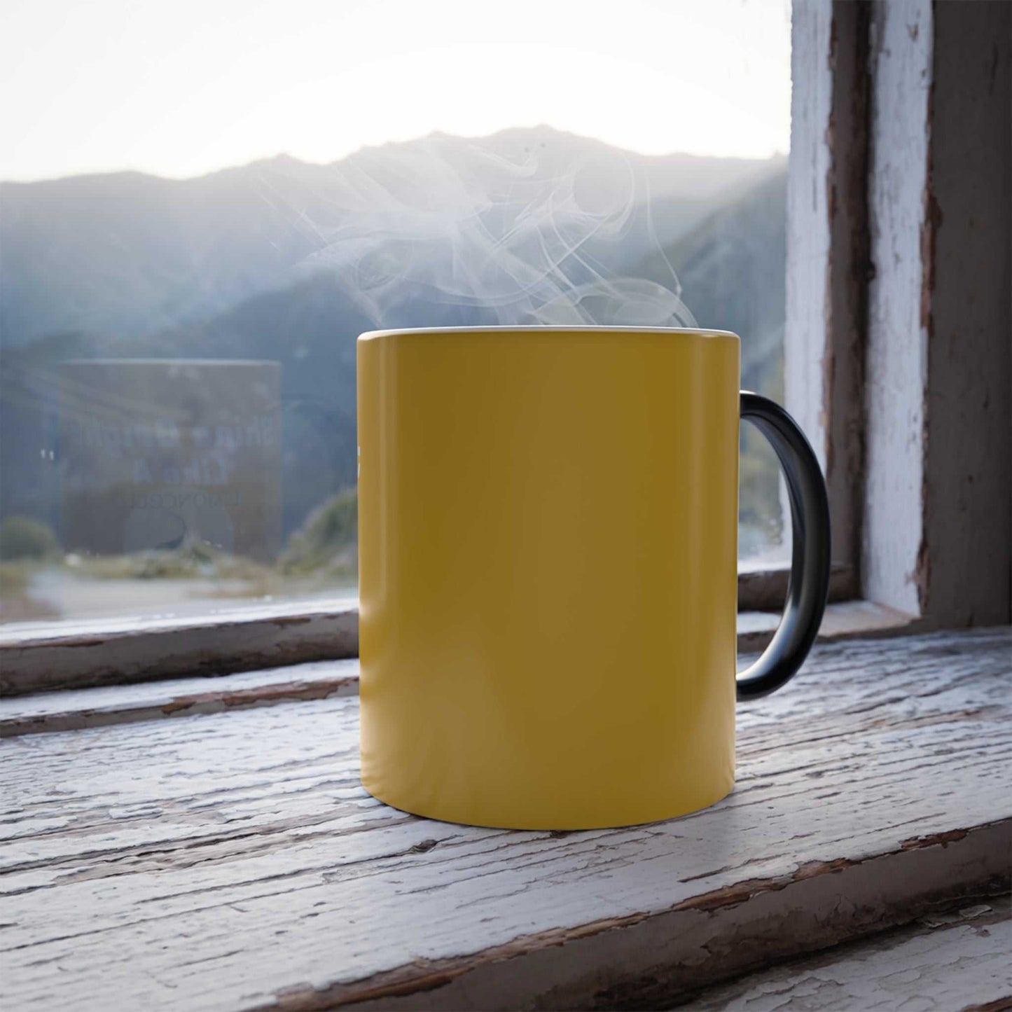 Yellow color changing mug with black handle steaming by window on wooden surface