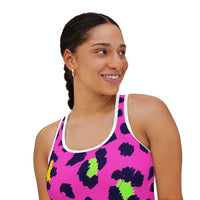 Woman wearing vibrant leopard print tank top with pink, black, and green spots and white trim