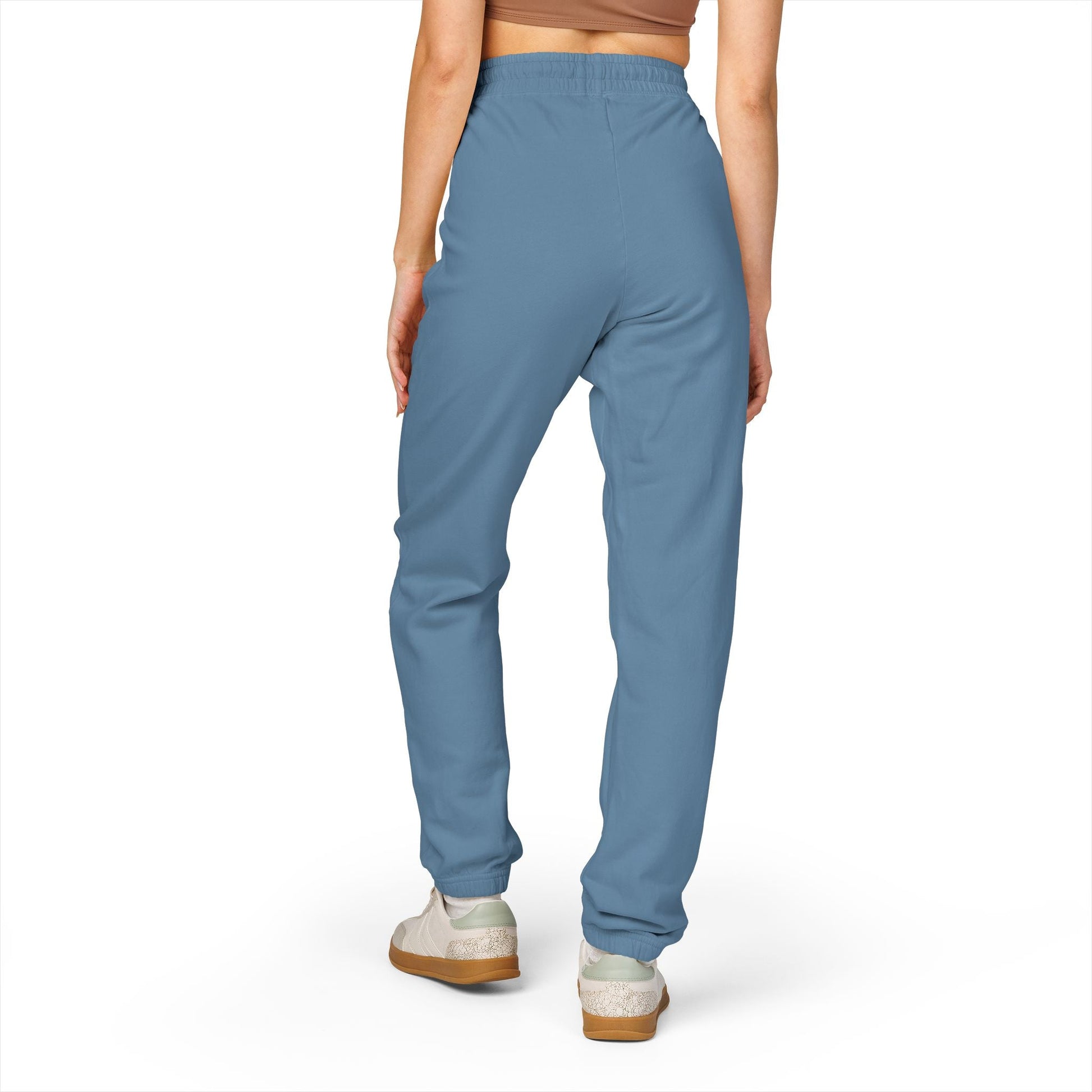 Rear view of person wearing comfortable unisex fleece sweatpants in blue with elastic waistband and cuffs