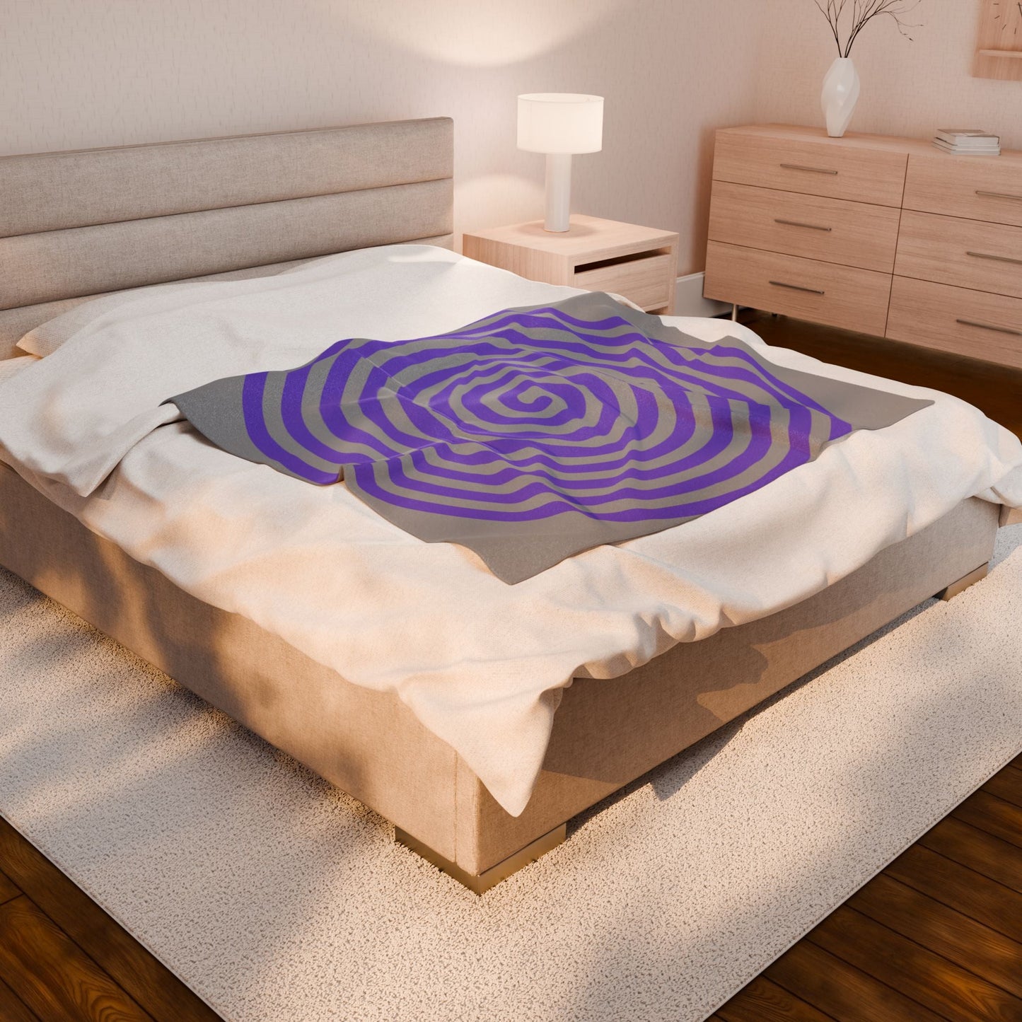 Plush blanket with purple spiral design on bed in cozy bedroom setting