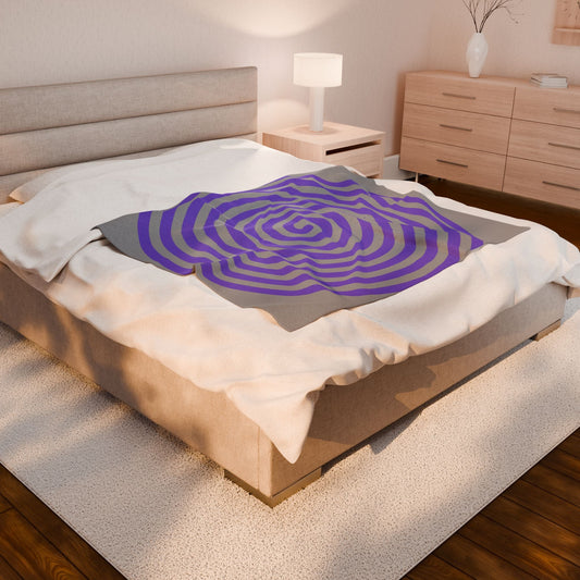 Plush blanket with purple spiral design on bed in cozy bedroom setting