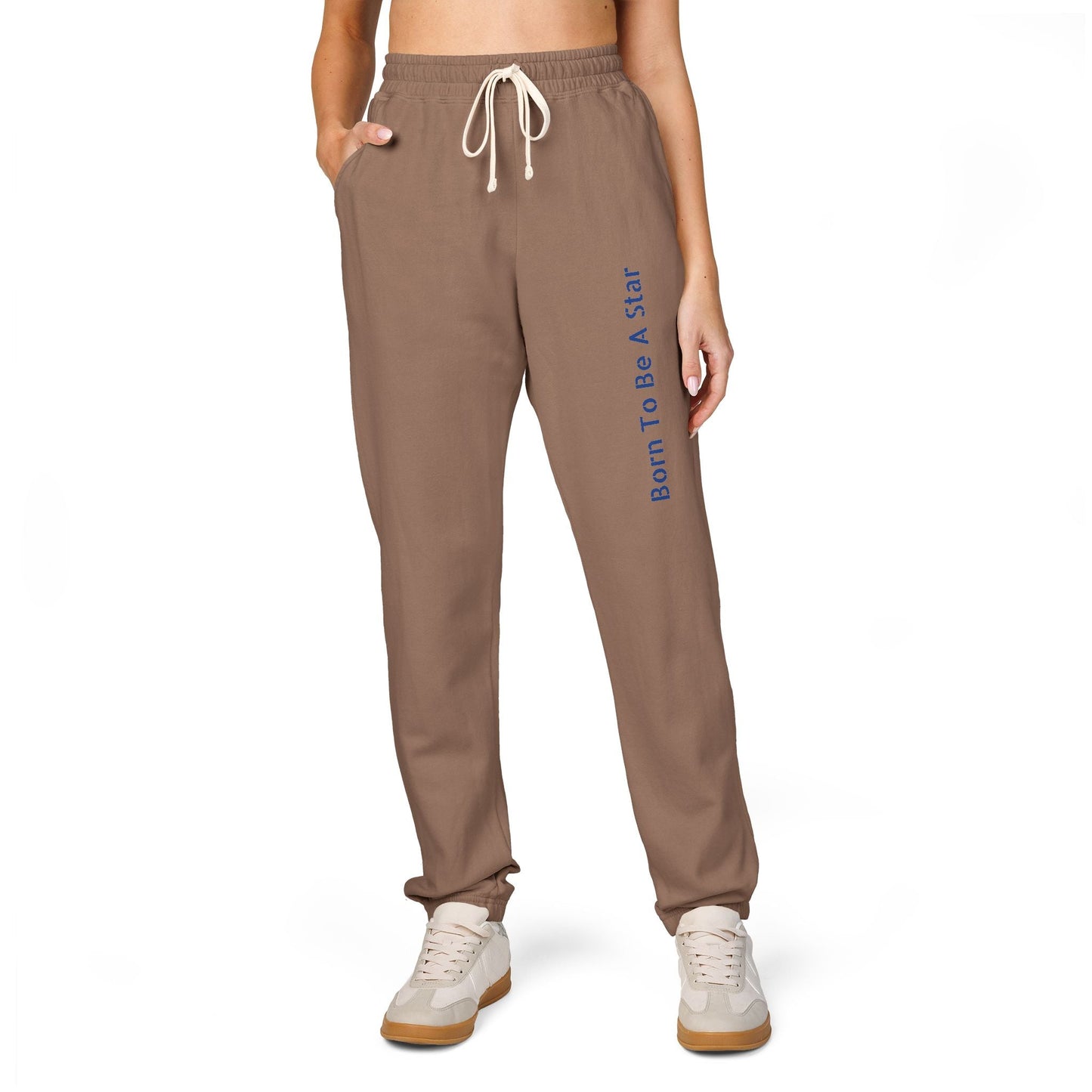 Unisex brown fleece sweatpants with drawstring waist and "Born To Be A Star" text, styled with white sneakers
