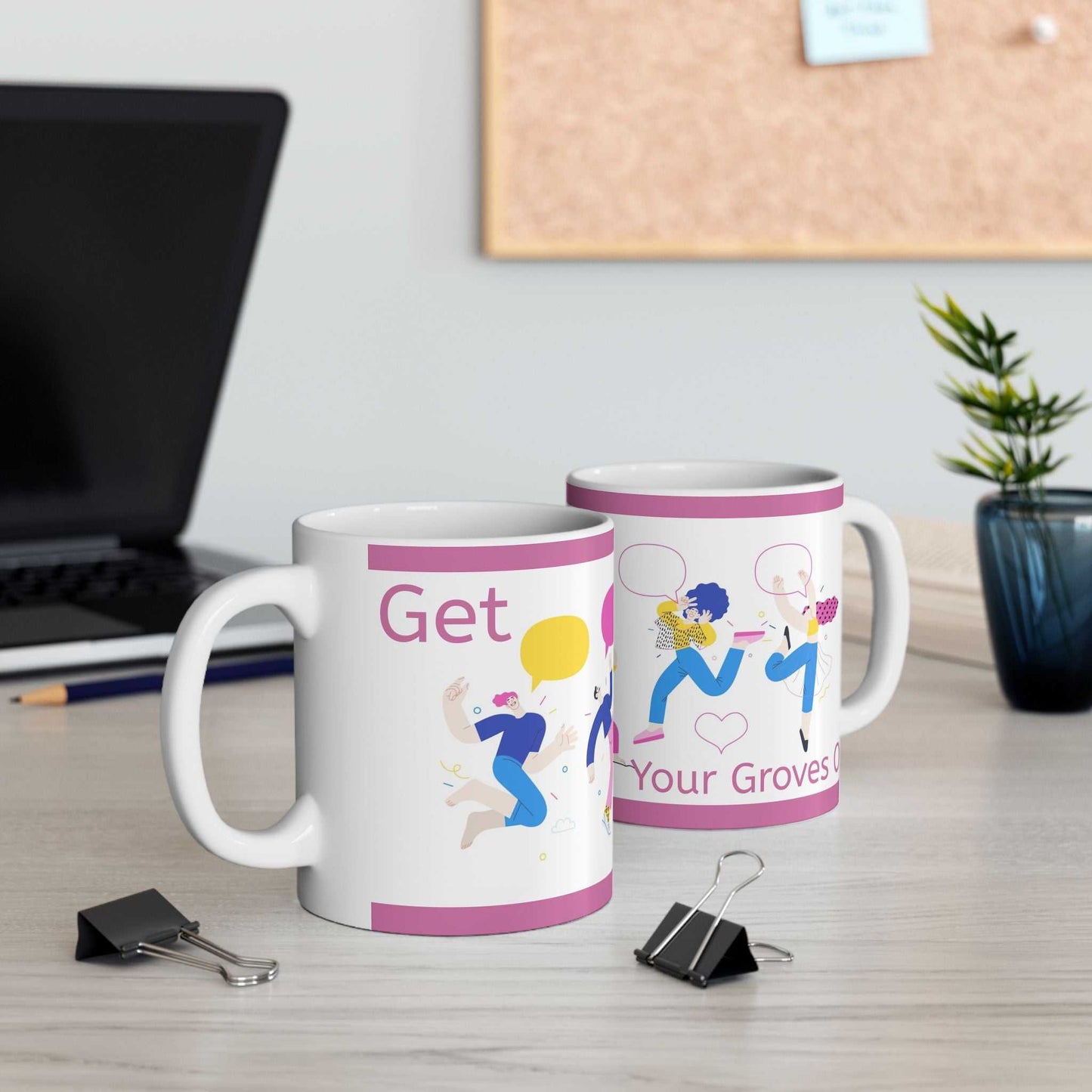 Two glossy ceramic mugs with "Get Your Groves On" text and colorful dancing character design on a desk near a laptop and plant
