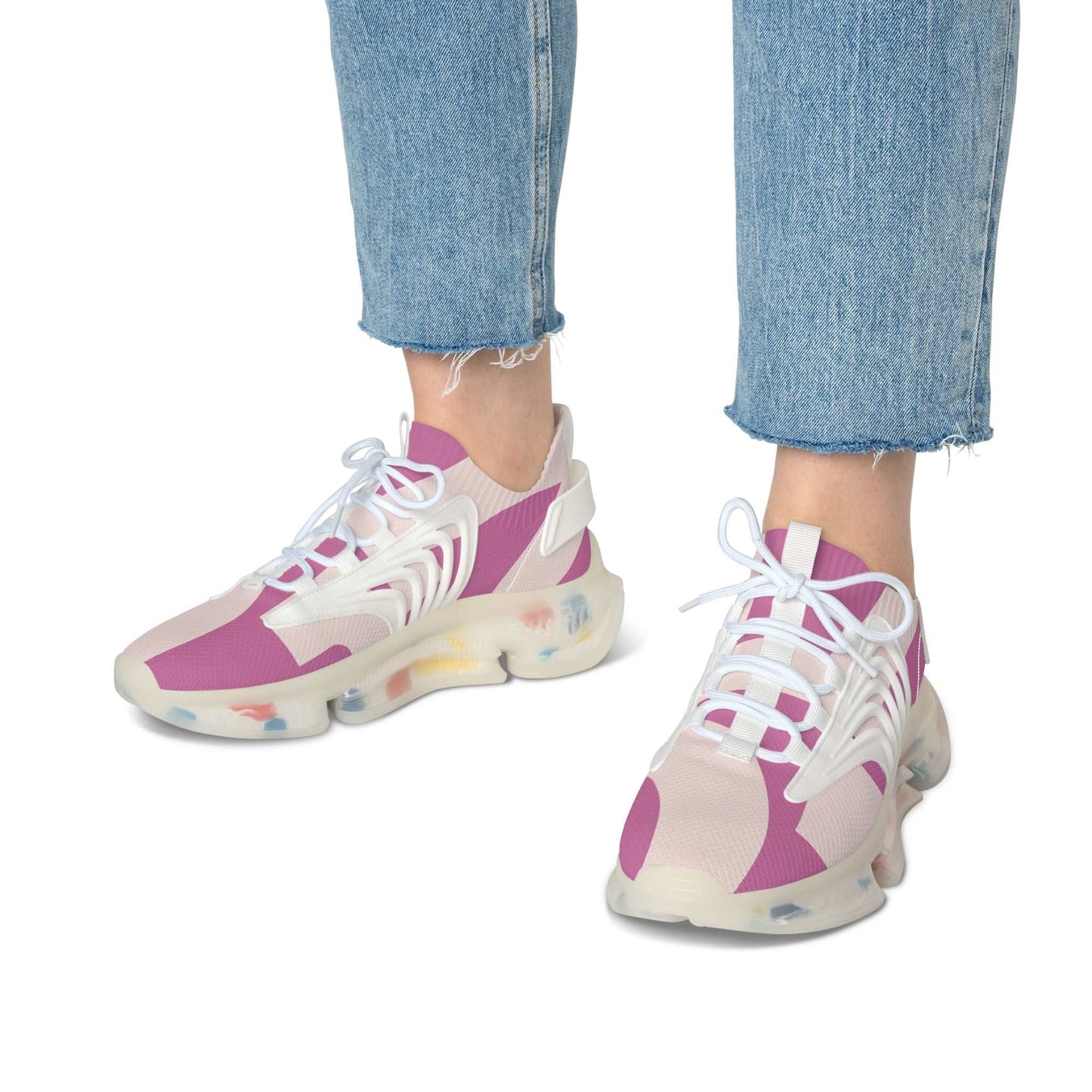 Women's mesh sneakers in pink and beige with white laces and multicolor sole worn with blue jeans