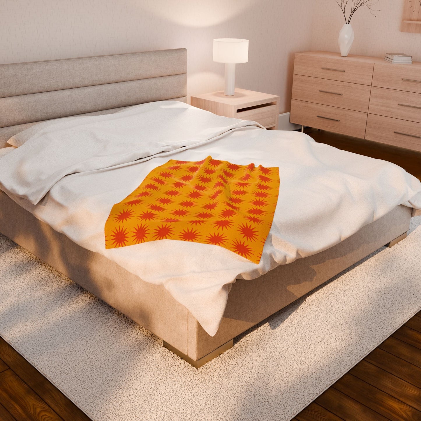 Cozy Velveteen Plush Blanket with vibrant orange and red sunburst pattern draped on modern bedroom bed
