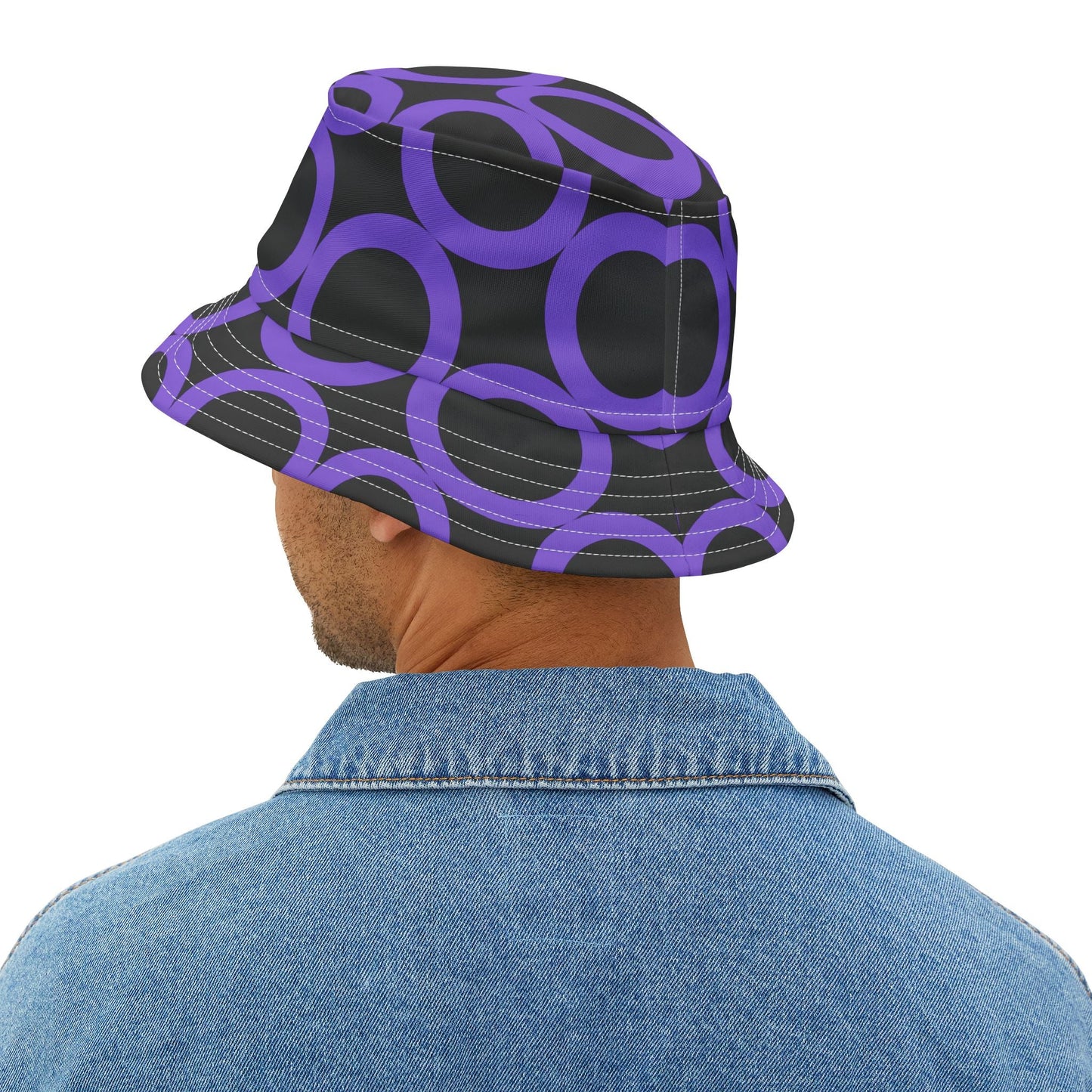 Man wearing purple dot pattern bucket hat with adjustable fit and denim jacket, black background