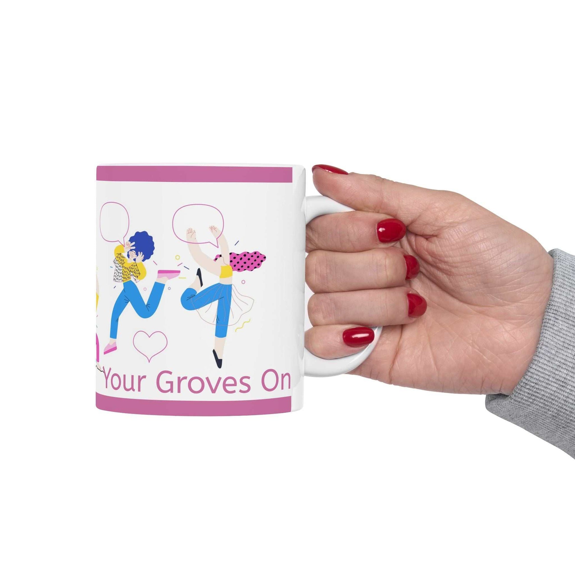 Hand holding Get Your Groves On ceramic mug with colorful dancing figures and pink accents
