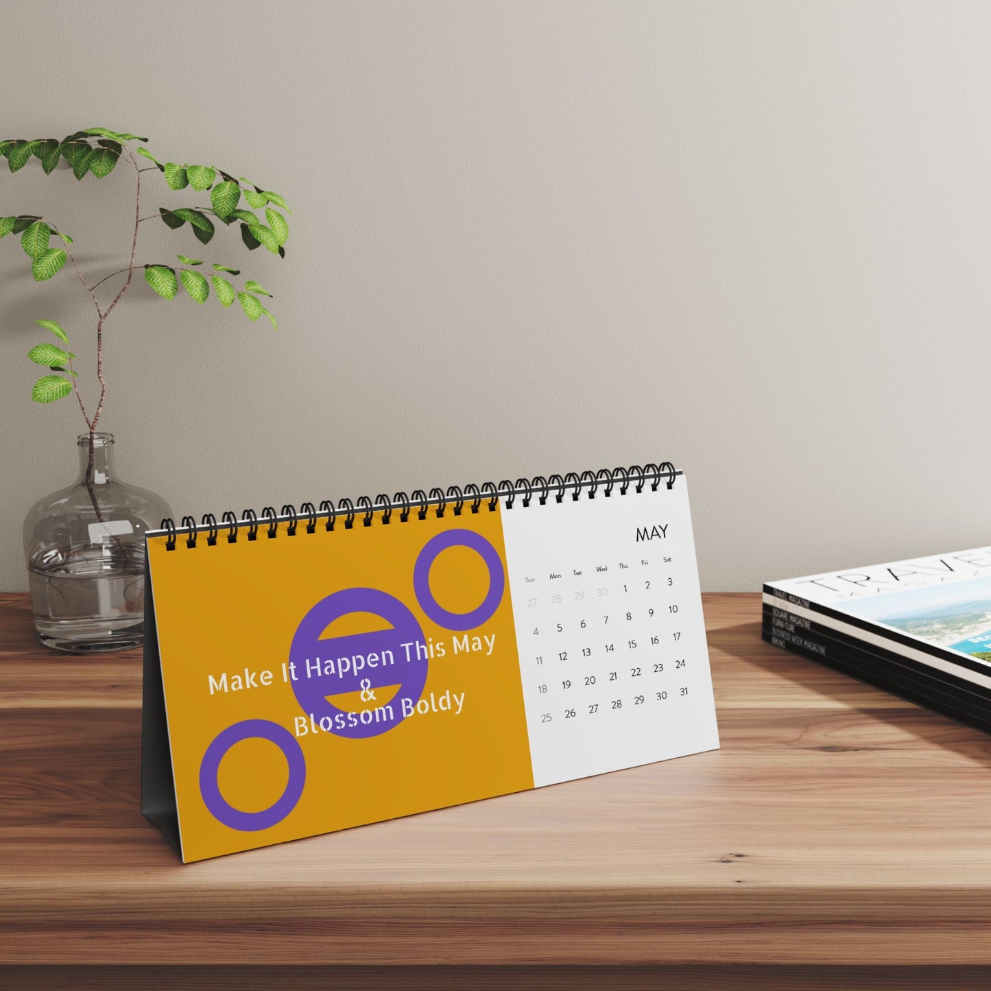 2025 desktop calendar with spiral binding and colorful May month grid on wooden desk