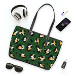 Stylish leopard print shoulder bag in green with black straps and gold hardware, shown with headphones, phone, sunglasses, and keys.