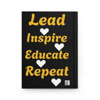 Hardcover journal with black cover featuring "Lead Inspire Educate Repeat" text and heart graphics in gold and white
