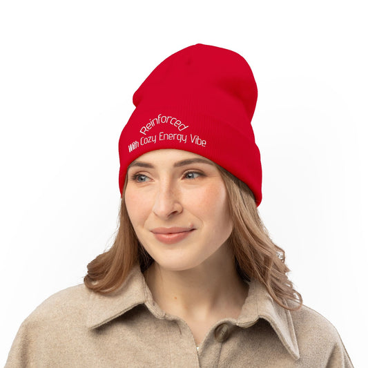 Red knit beanie with embroidered text worn by woman in beige coat winter headwear accessory