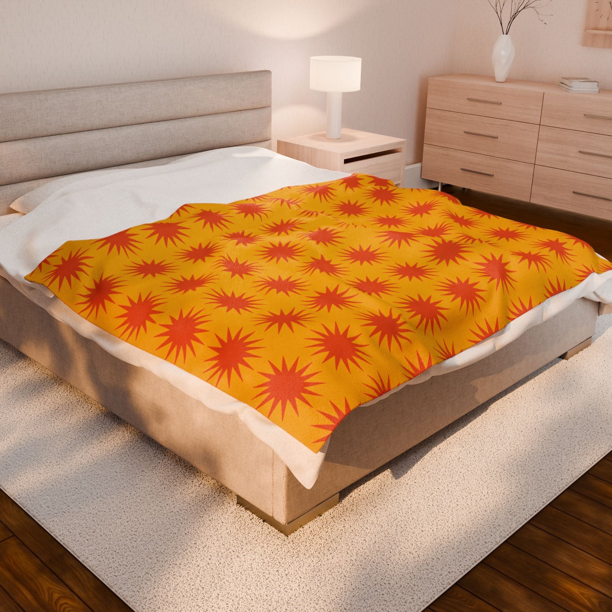 Cozy Velveteen Plush Blanket with vibrant orange starburst pattern on bed in modern bedroom
