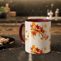 Fall Cozy Season Mug with colorful autumn leaves design and burgundy handle on kitchen countertop