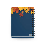 Autumn-inspired spiral bound journal with colorful fall leaves on dark blue cover for creative writing and reflection