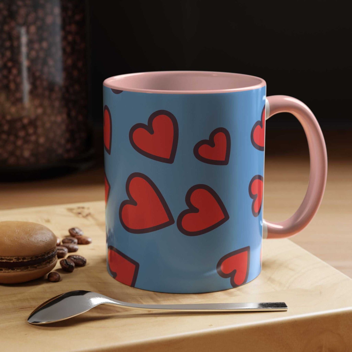 Blue Vibrant Love Accent Coffee Mug with red hearts and pink handle on wooden table with spoon and macaron