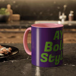 Colorful custom mug with purple exterior and pink interior, featuring bold green text, on a kitchen counter.