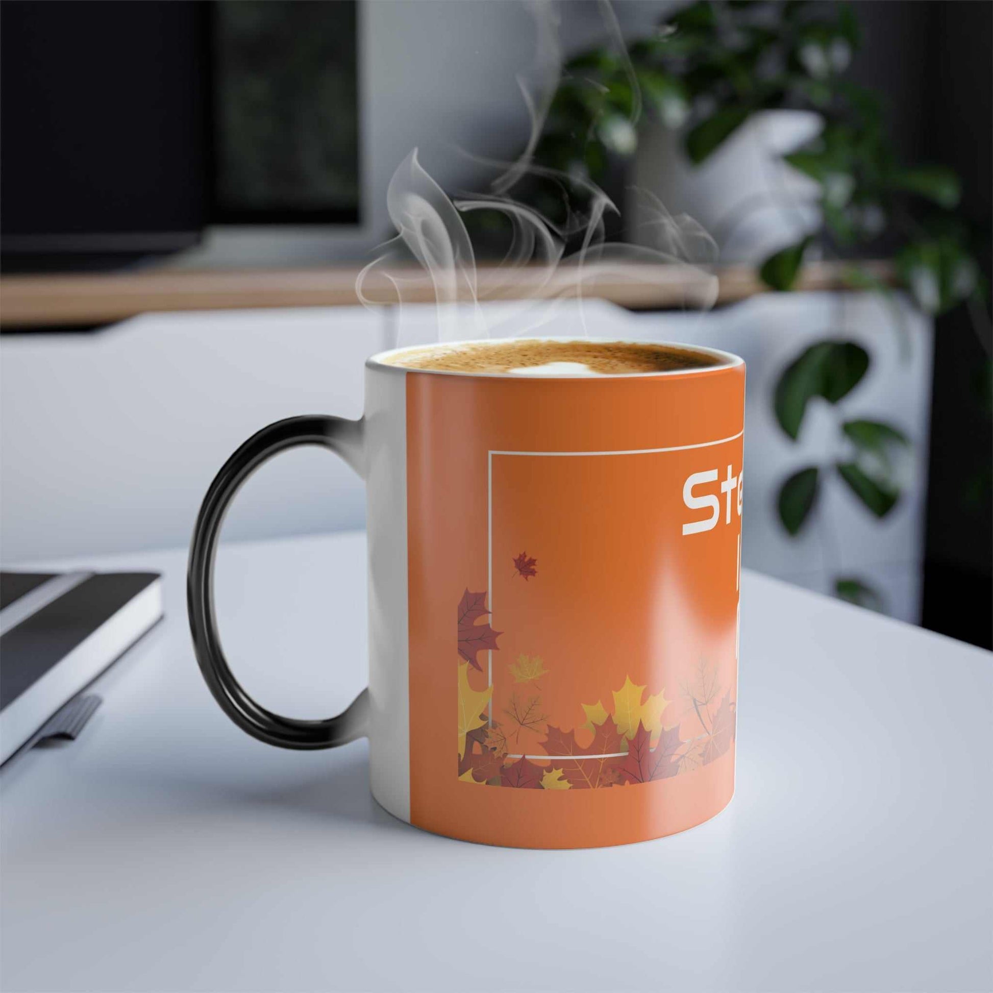 fall-themed color morphing mug with steaming hot coffee on white table