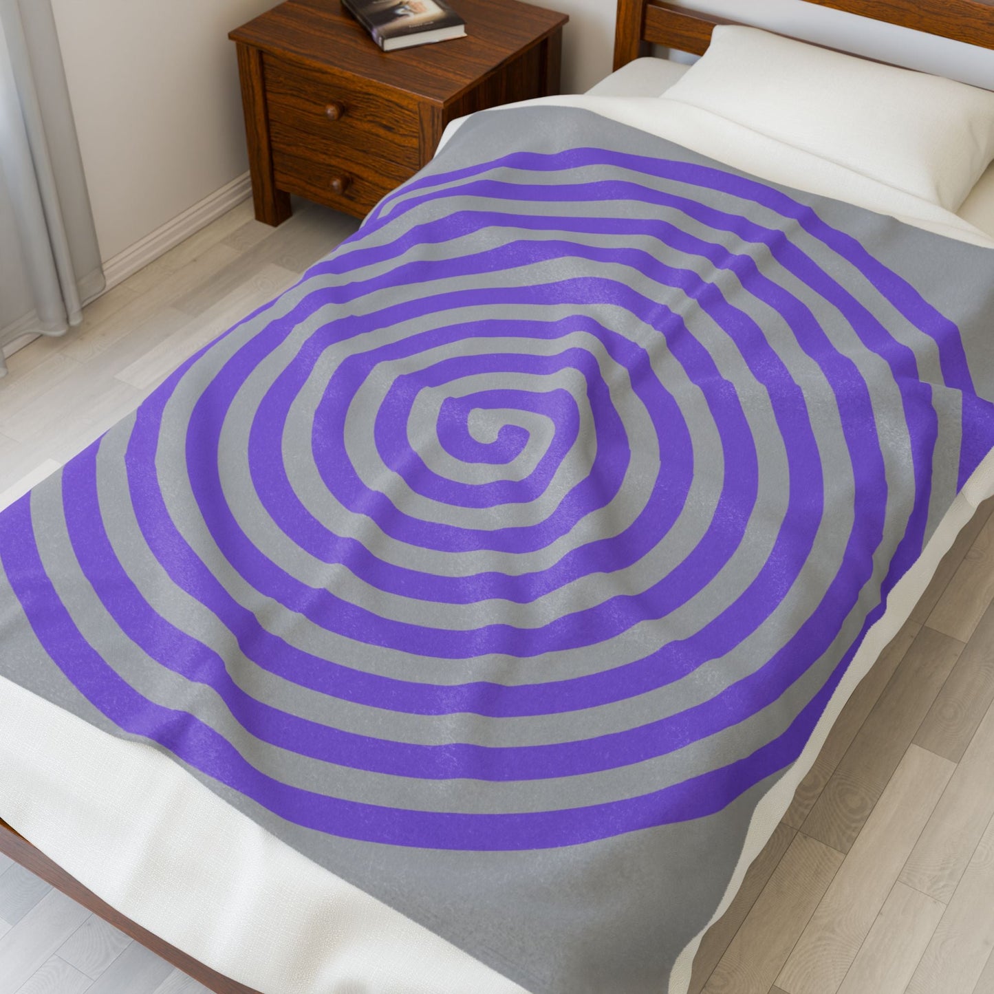 plush blanket with purple spiral design on bed in cozy bedroom setting
