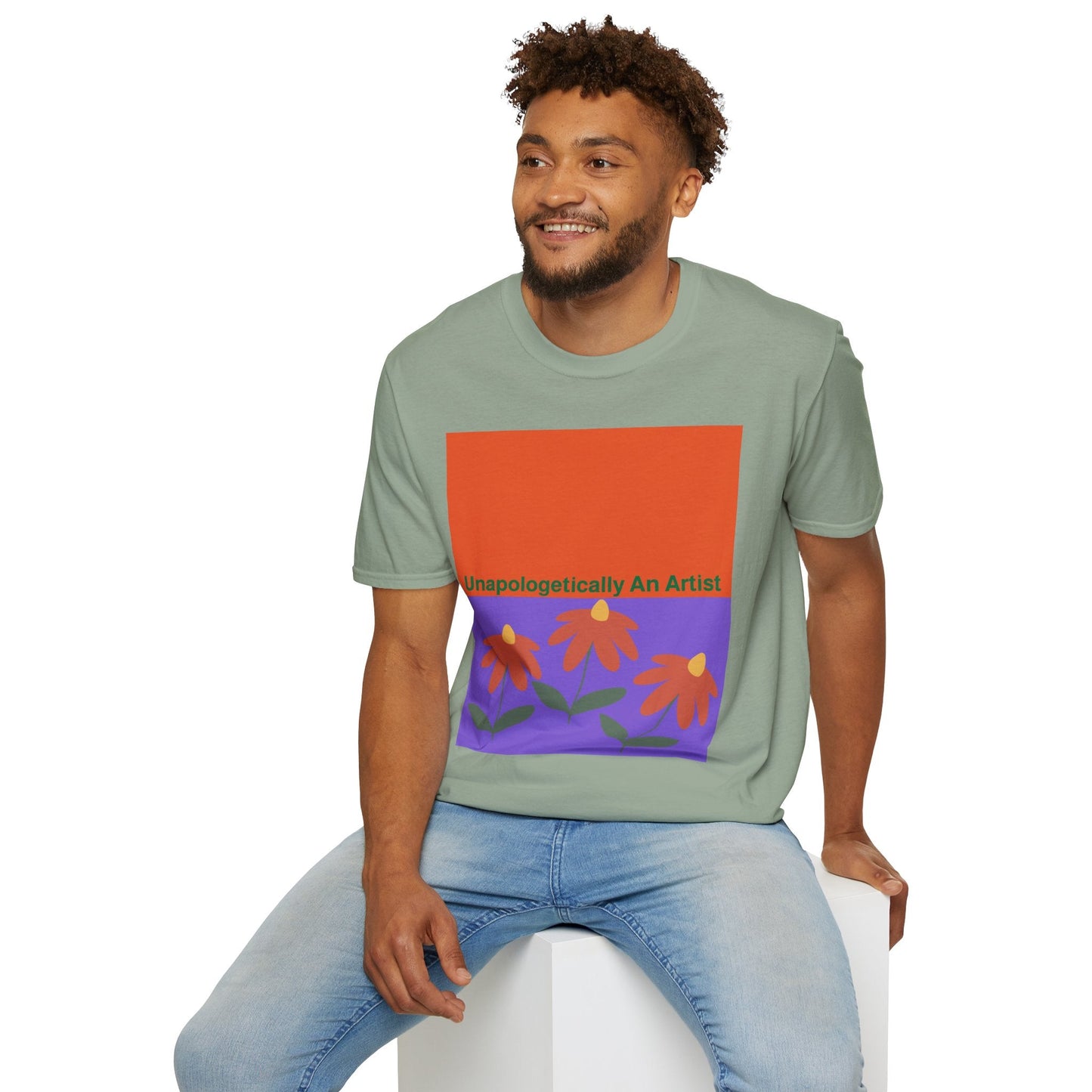 man wearing green Unapologetically An Artist T-Shirt with floral design sitting on white block
