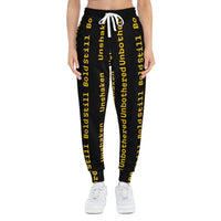 Eco-friendly black joggers with yellow "Unbothered Unshaken Bold Still" text, adjustable white drawstring waist, and side pockets.