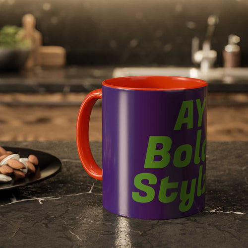 Colorful custom mug with purple exterior and orange handle and interior, featuring green text, on kitchen countertop