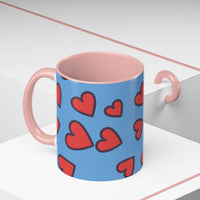 Vibrant Love Accent Coffee Mug with red hearts design and pink interior and handle on blue ceramic background