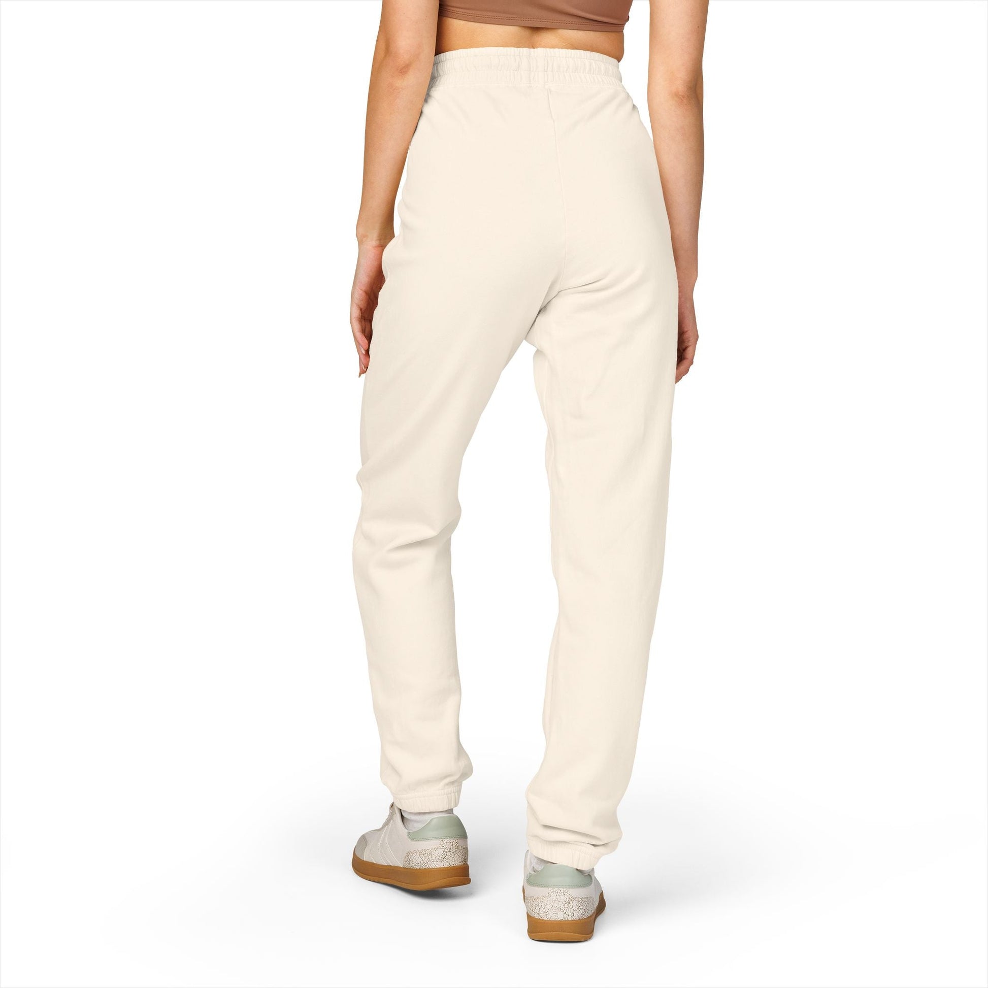 Back view of person wearing comfortable unisex fleece sweatpants in light cream color with elastic waistband and relaxed fit