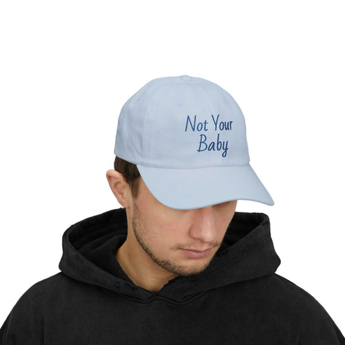 Classic Cap with Not Your Baby embroidery in light blue worn by man in black hoodie