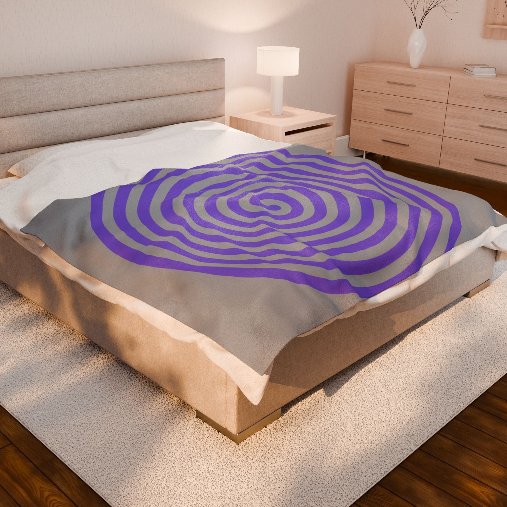 Plush blanket with purple spiral design on beige bed in modern bedroom setting