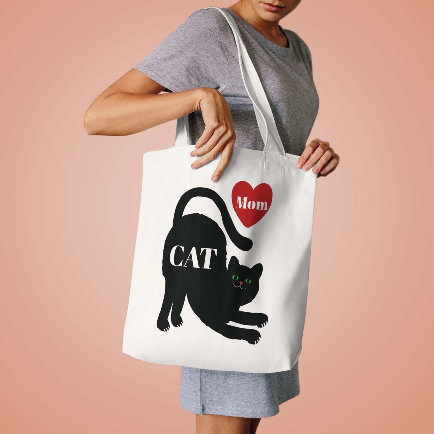 Woman holding white Cat Mom tote bag with black cat and red heart design on cotton canvas
