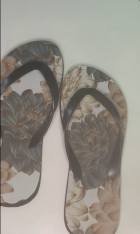 Pair of floral-patterned flip-flops on a light background